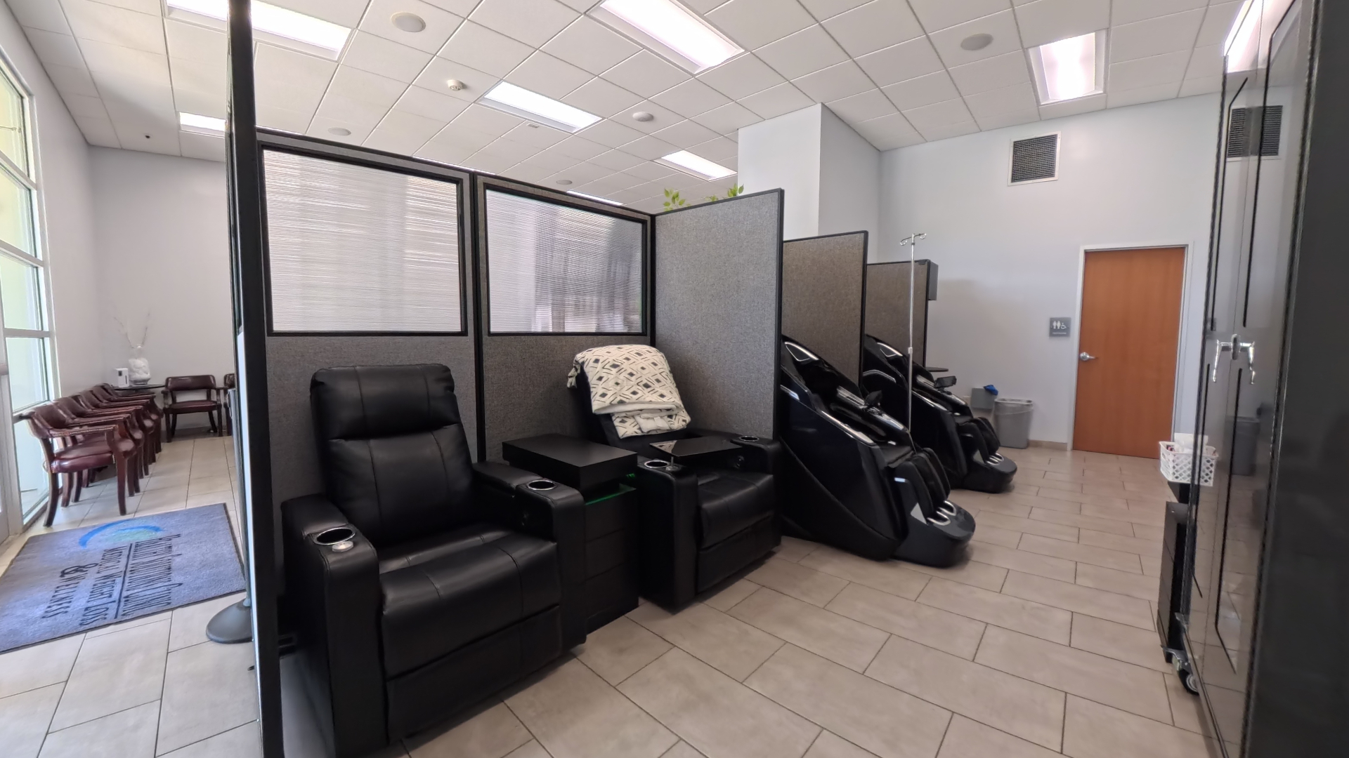 Power recliners with pillows, blankets, side tables, and semi-private dividers in Healthy Solutions Clinic